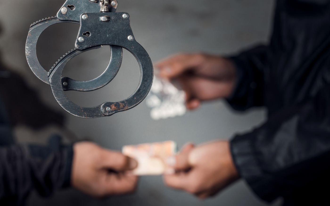 Handcuff and drug dealer selling drugs