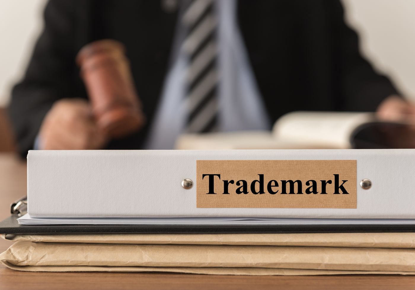 Trademark folder with attorney holding gavel in background