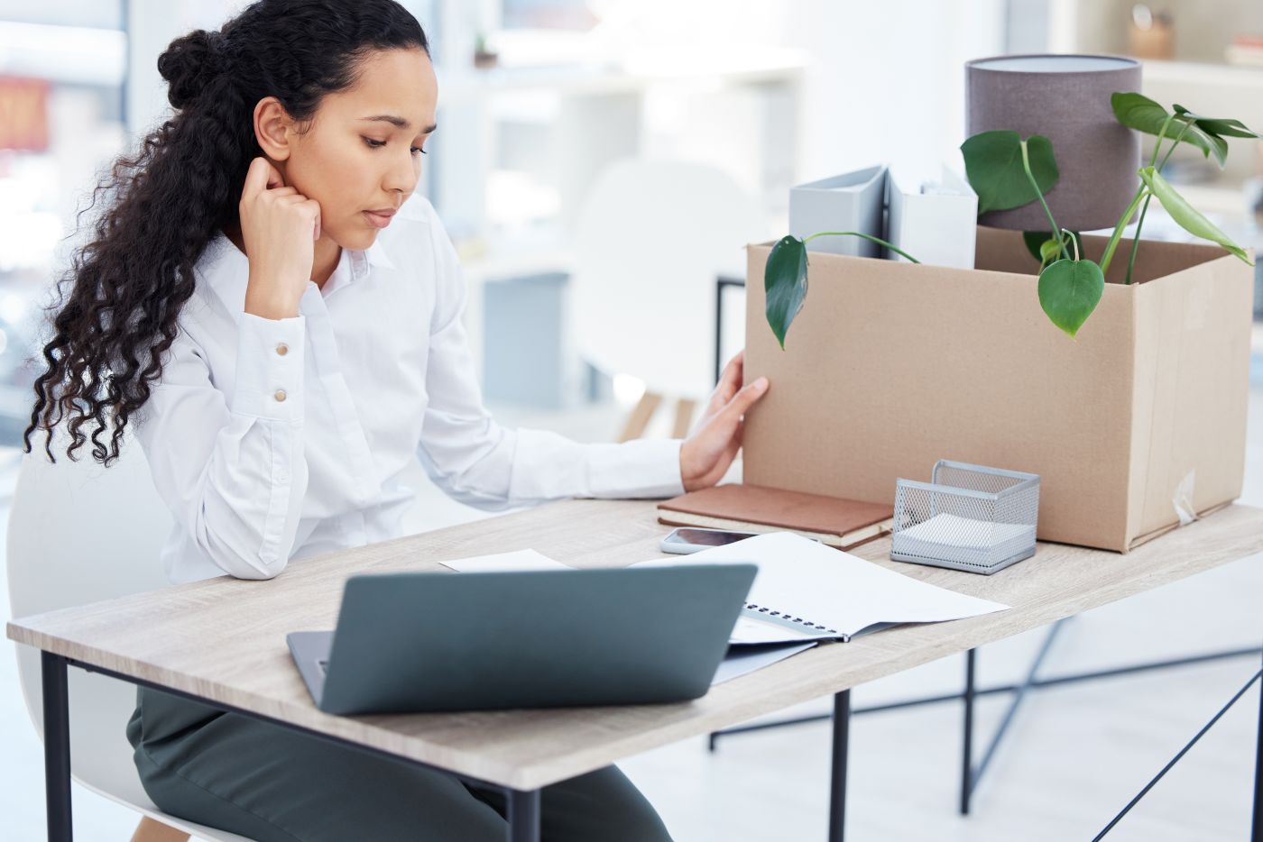 Sad women packing things in office after being terminated