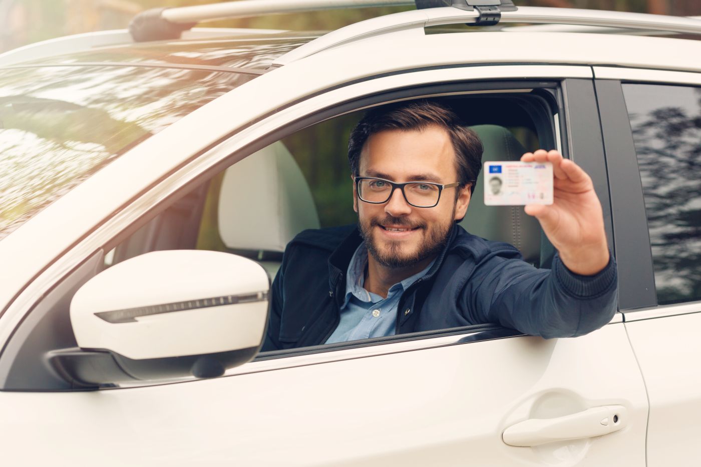 Happy man showing off his license