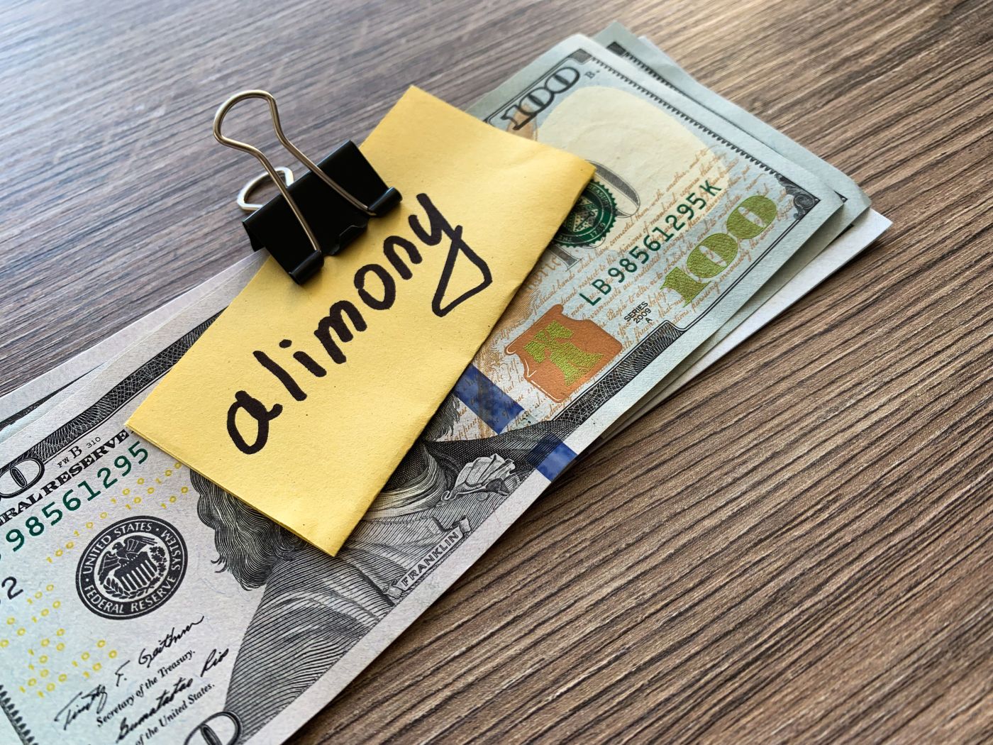 Dollar bill and word alimony on note