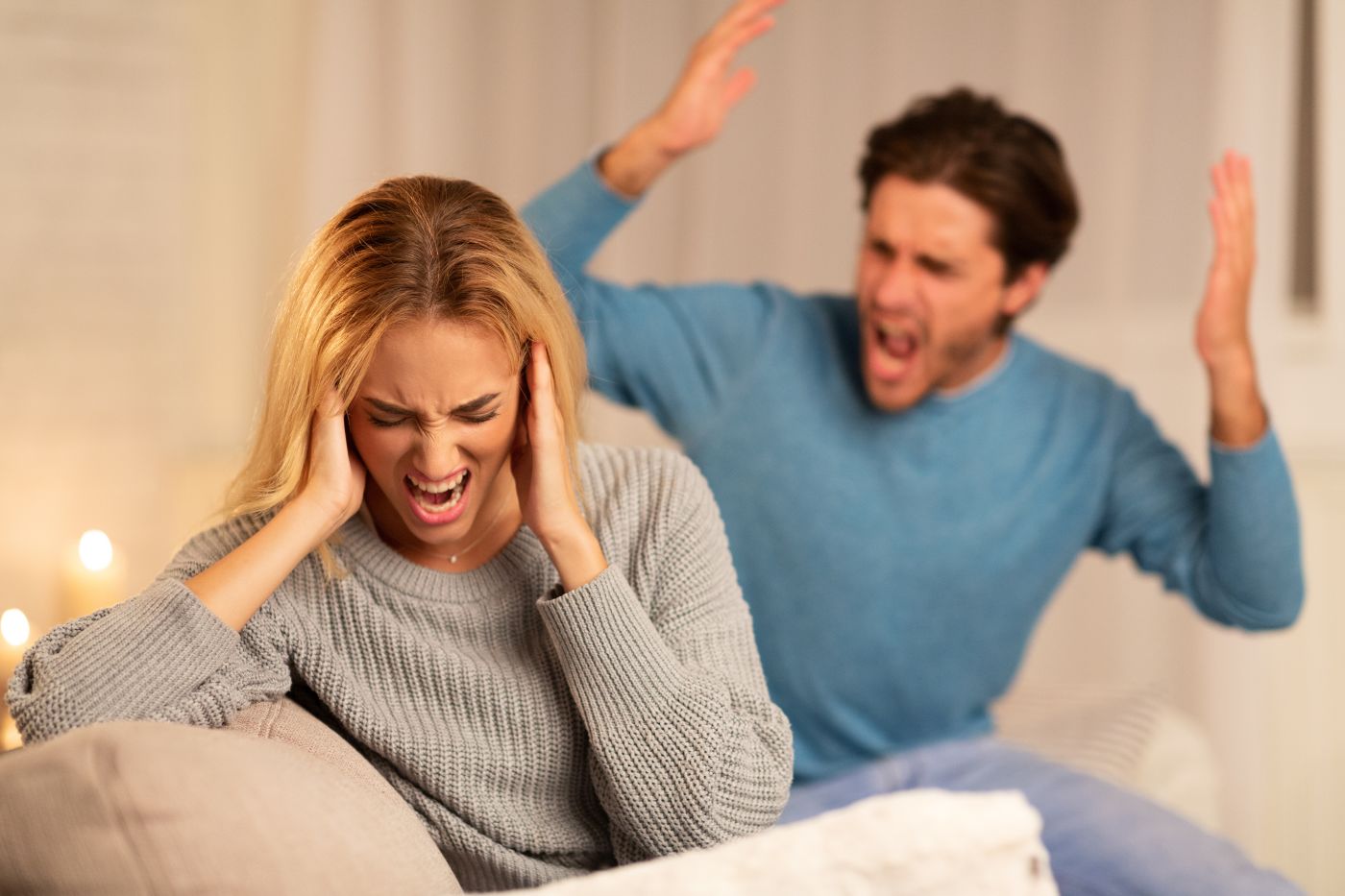 Aggressive Man Shouting at Woman Sitting on Sofa