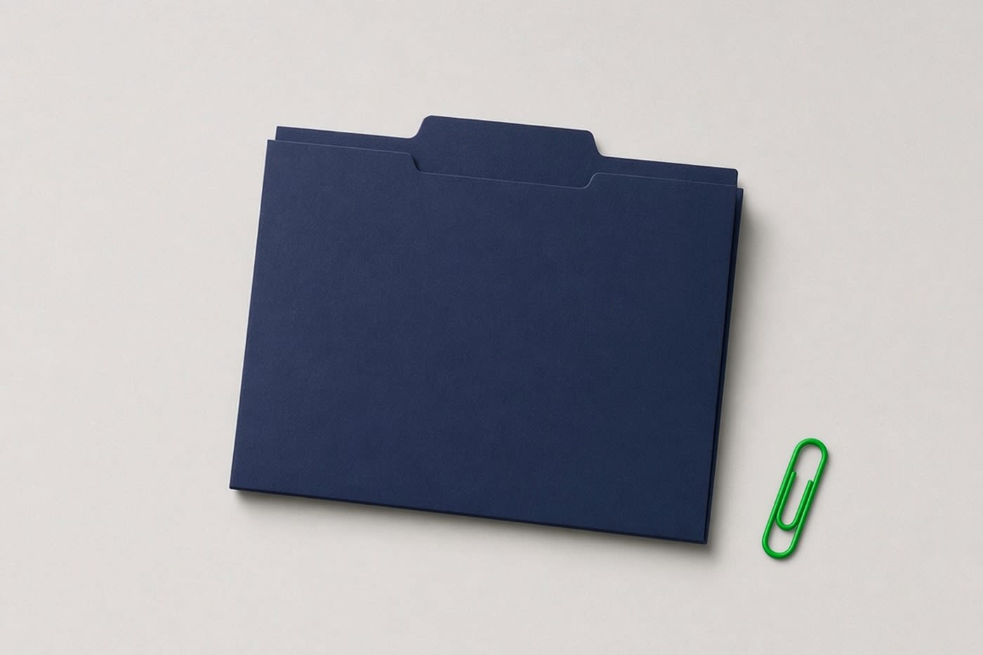 Navy file folder with a single green paper clip set apart