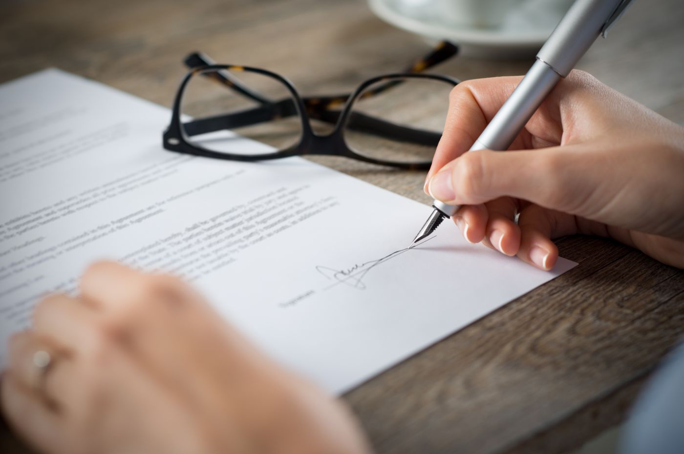 Women signing contract paper