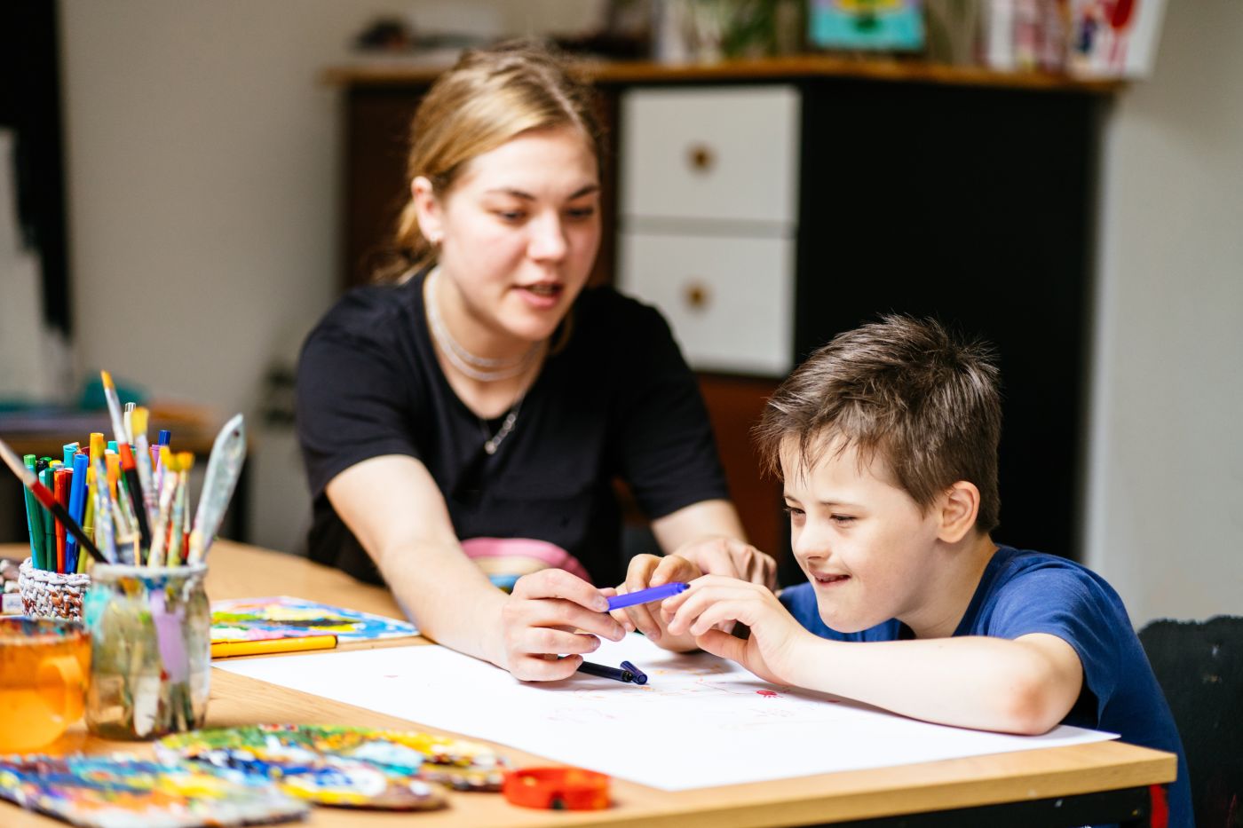 Young teacher with special need child at class