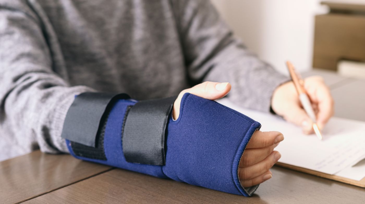 Man with injured hand filling in compensation form