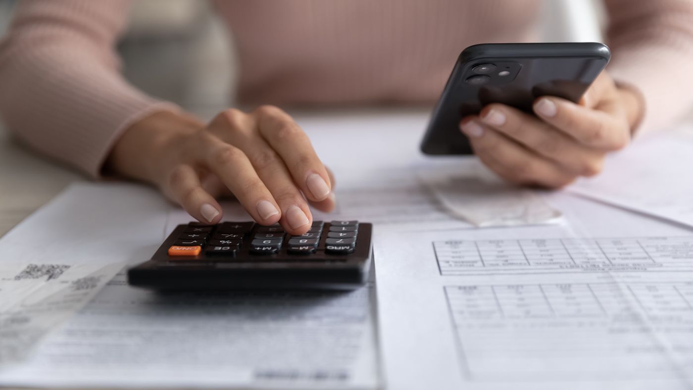 A woman calculating expenses from her phone