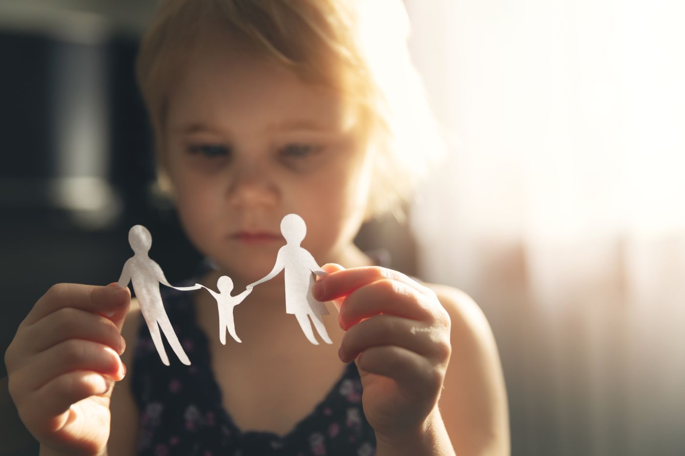 Little girl with paper family in hand