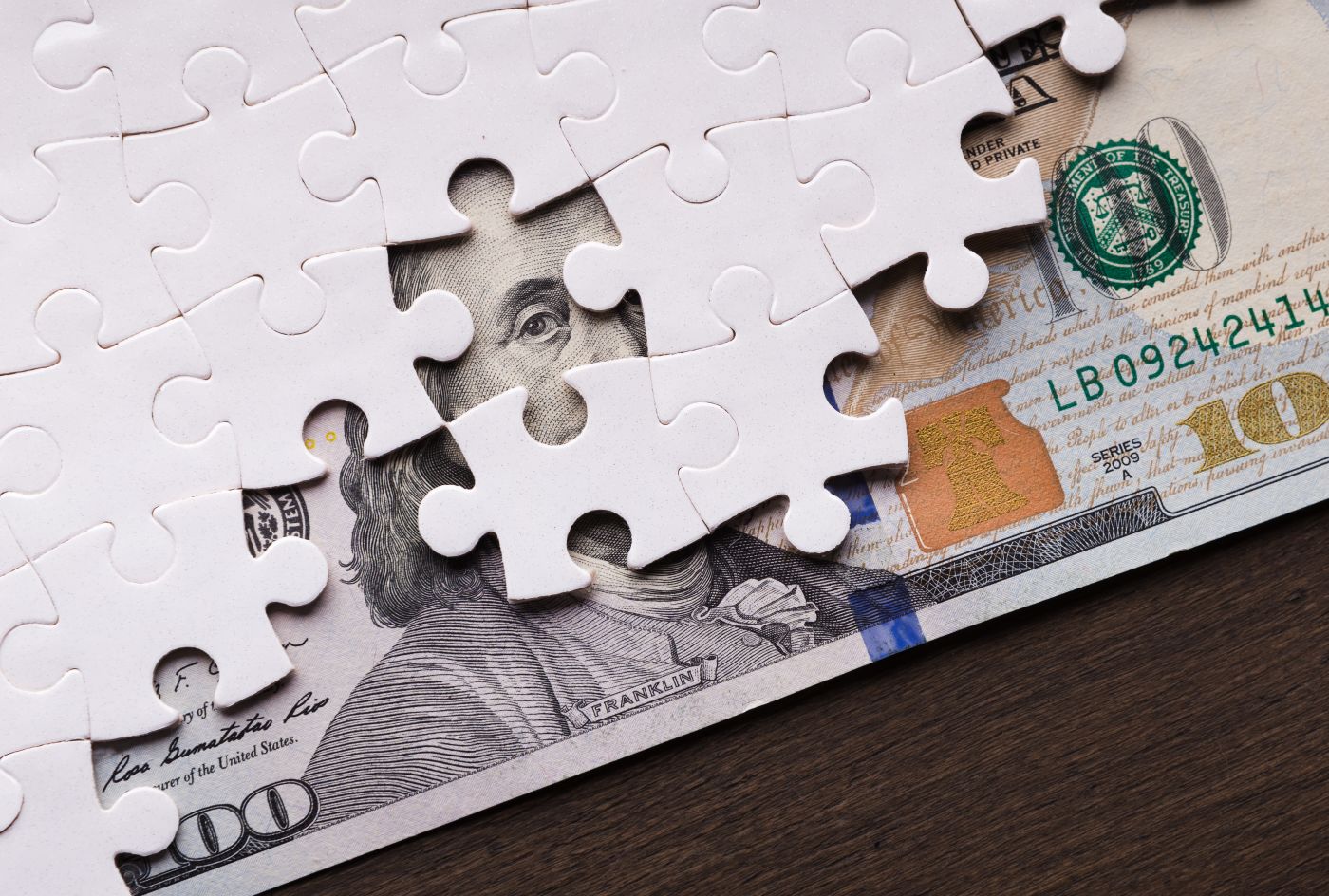 Hidden dollar bills under puzzle pieces