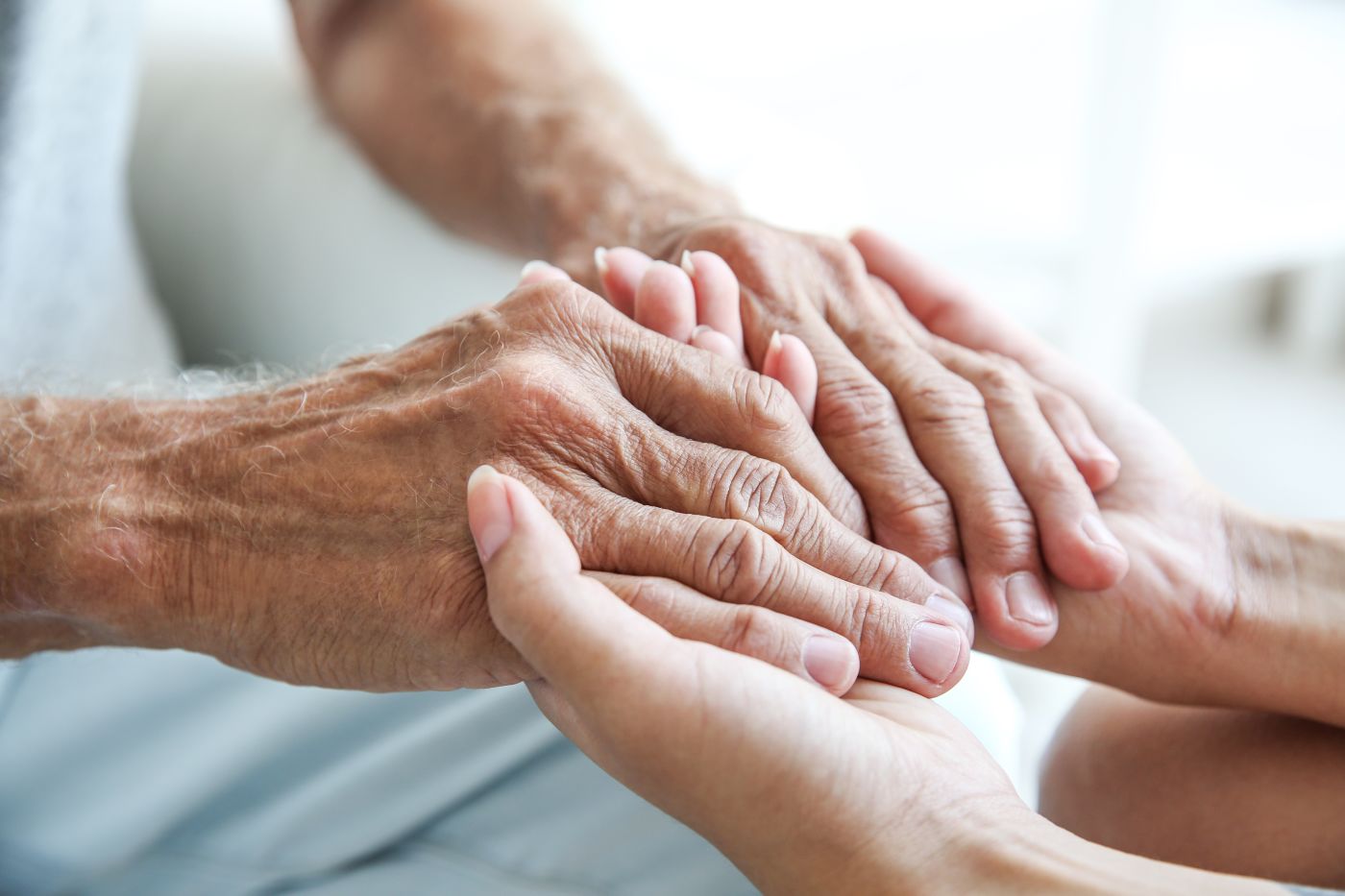 Young hands holding hands of an elder person