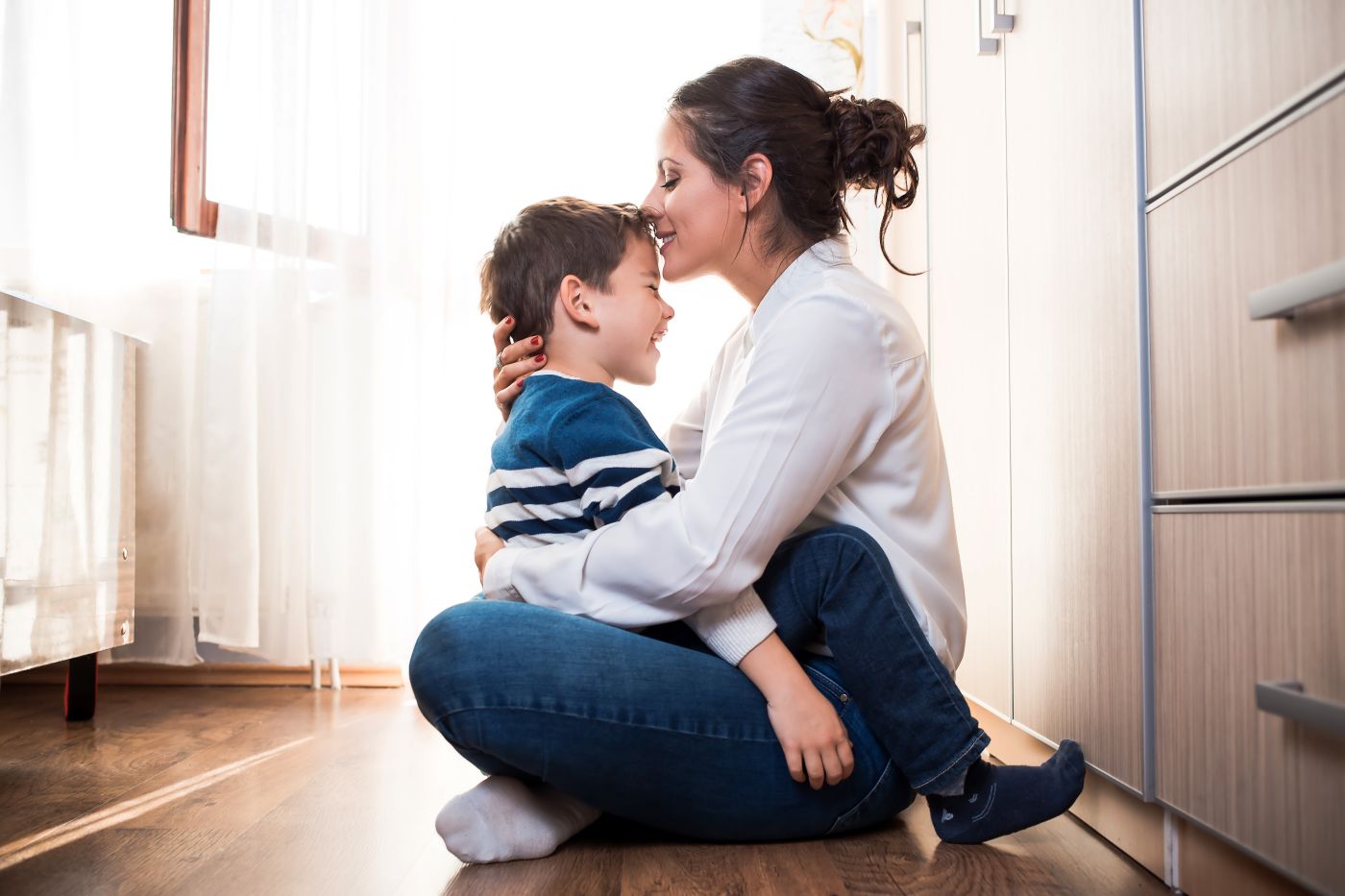Mom hugging her child and kissing in forehead