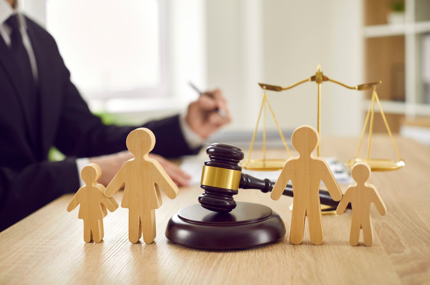 Family figurines, gavel in table with lawyer in background