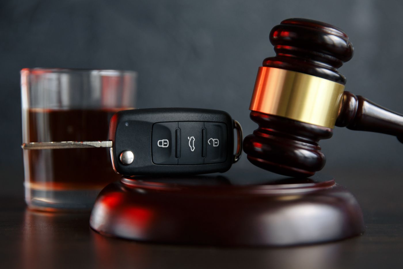 Law hammer, alcohol and car keys on wooden table