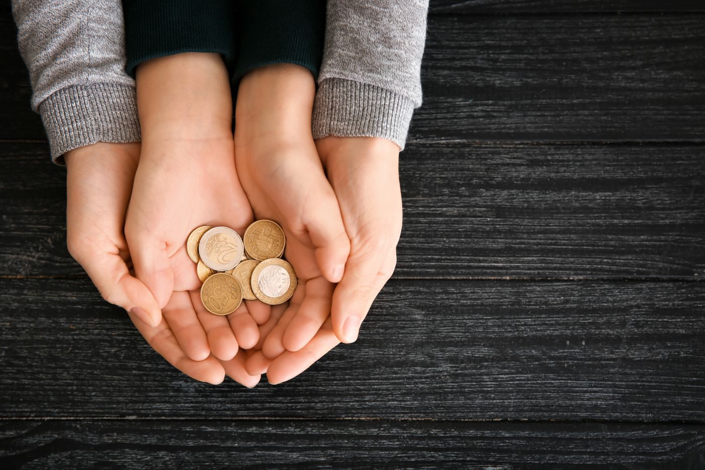 Mother and her child holding coins in hand