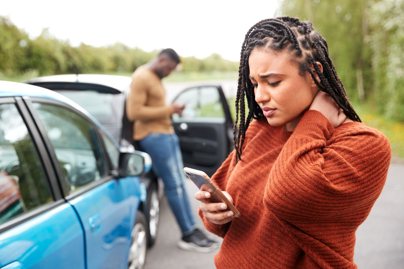 Women with neck pain after car accident calling for help