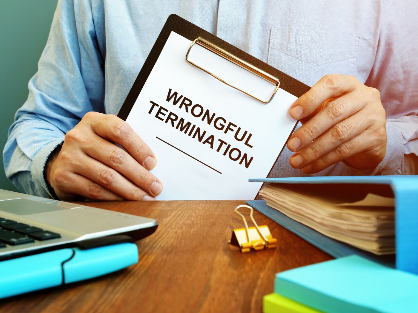 Employee holds papers about wrongful termination