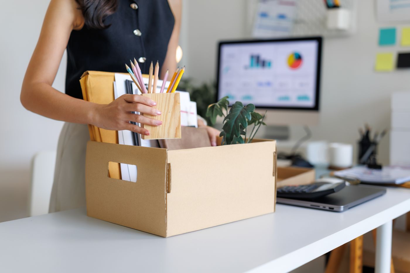 Office worker packing personal belongings after dismissal from job