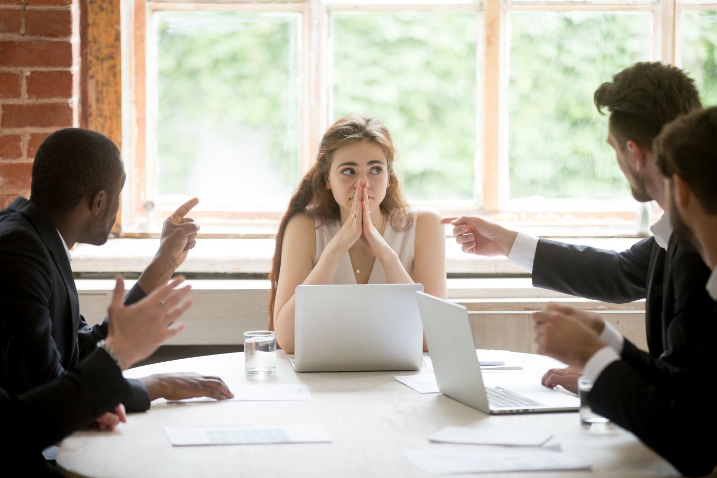 Female worker being blamed by male co-workers