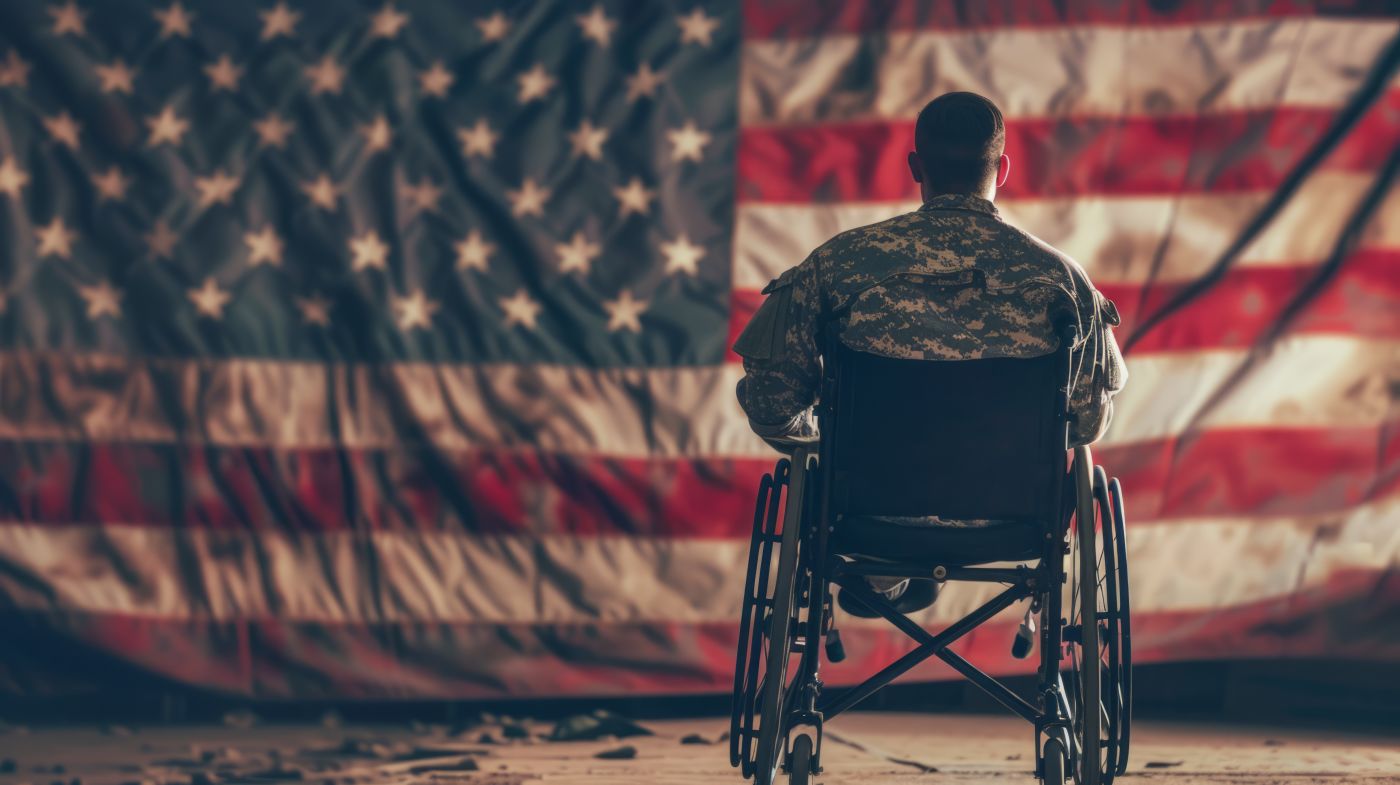 Veteran in wheelchair against American flag backdrop