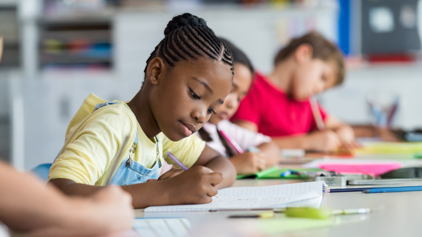 A girl writing at her desk in school.
