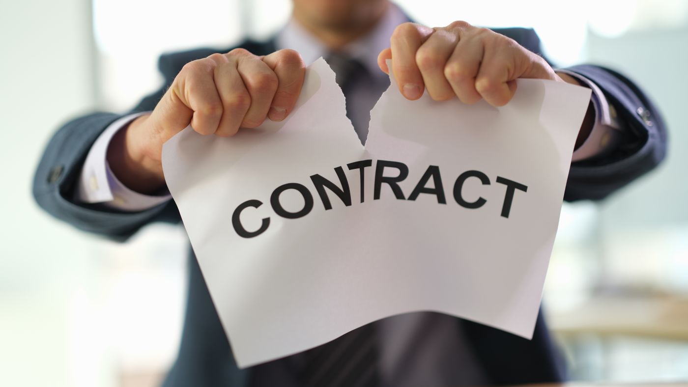 Businessman tearing contract paper