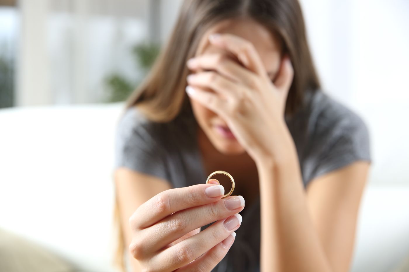 Crying women with wedding ring in hand