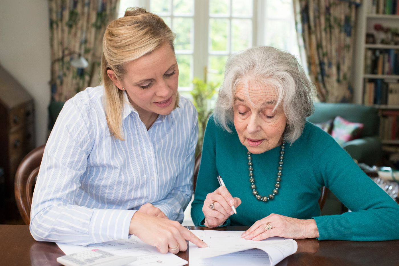 Senior women review and sign estate plan document