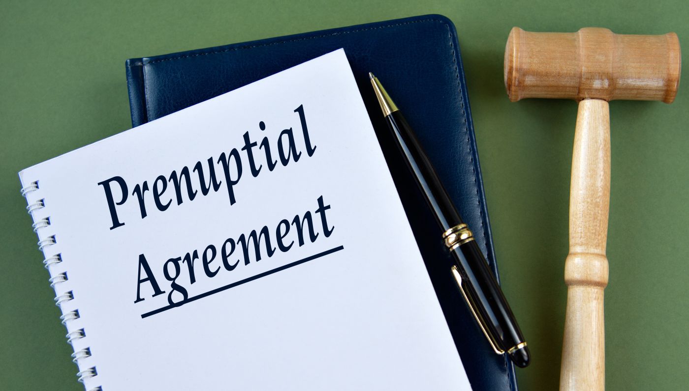 PRENUPTIAL AGREEMENT words on a white sheet with a judge's gavel