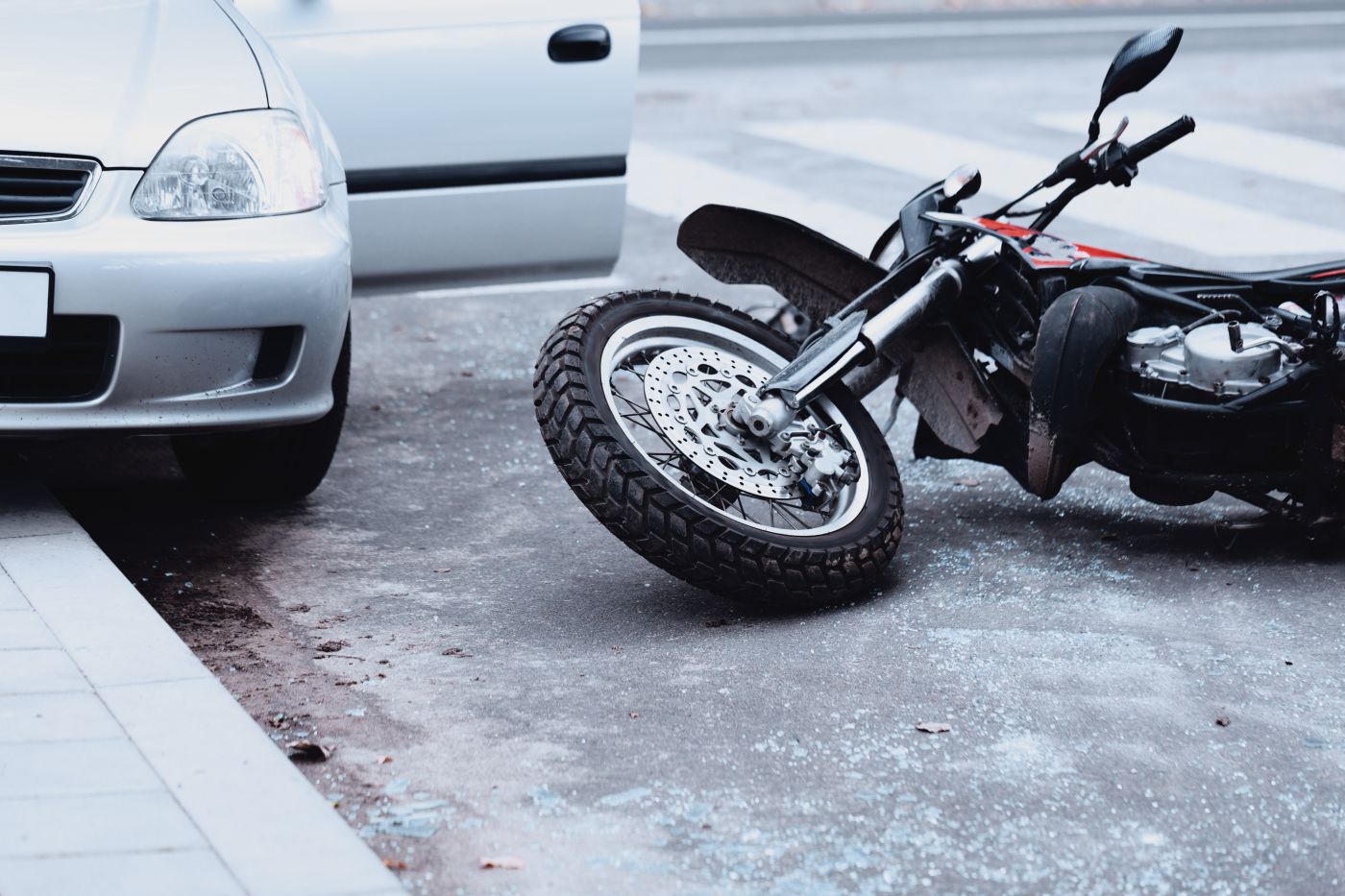 Motorbike on road after crash with car