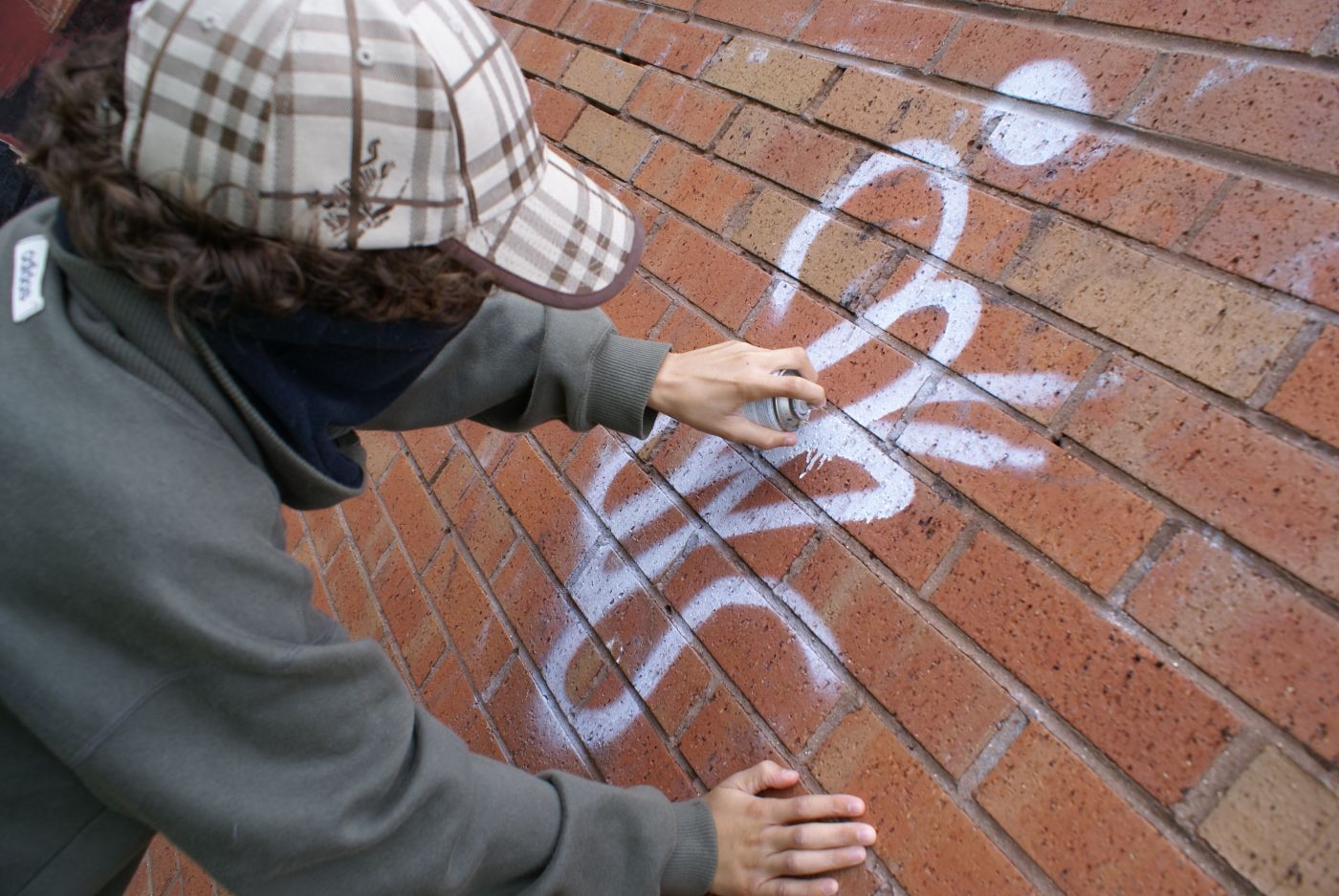 Masked person vandalizing public property