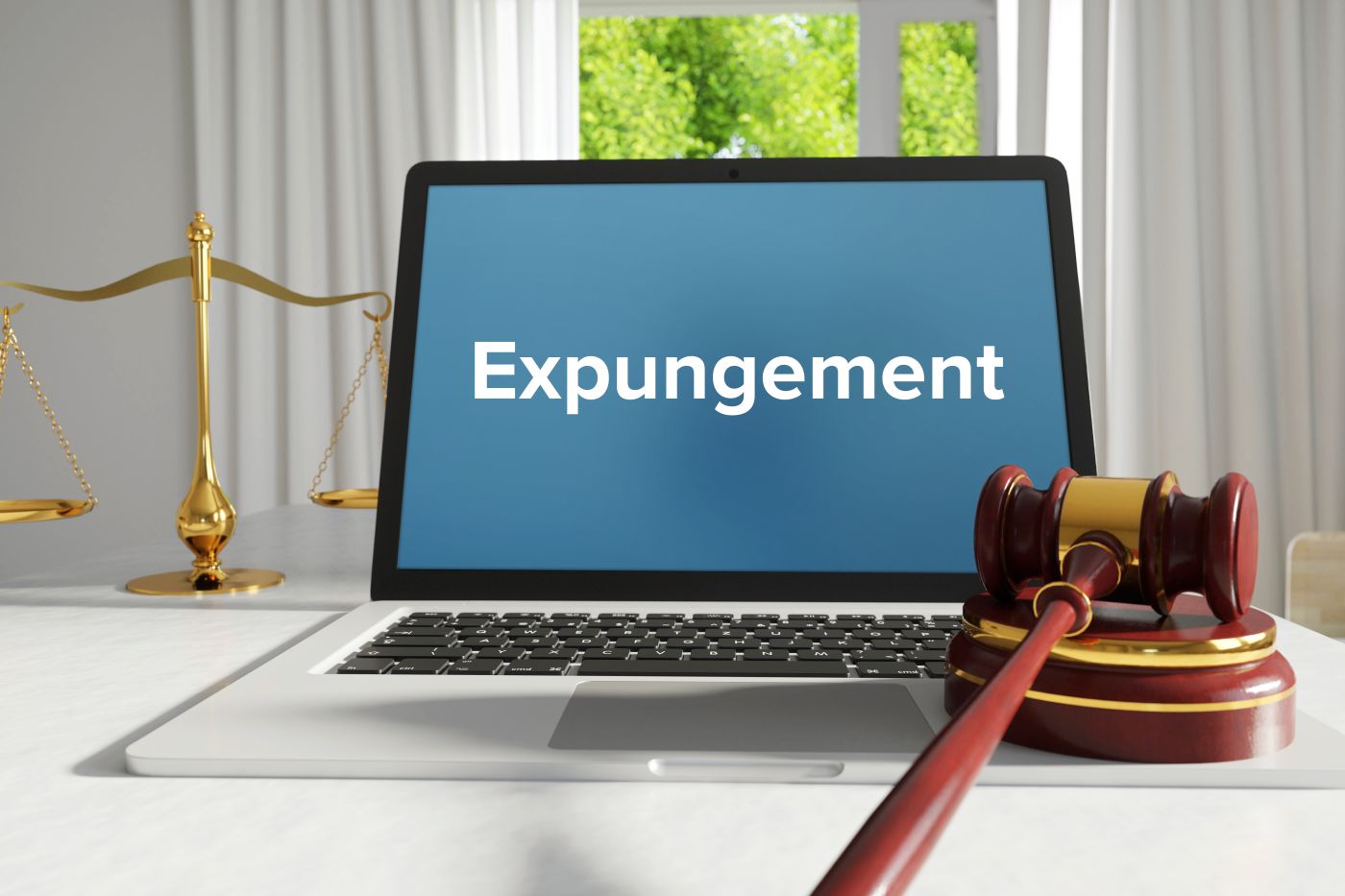 Expungement word on laptop screen with gavel and scale of justice