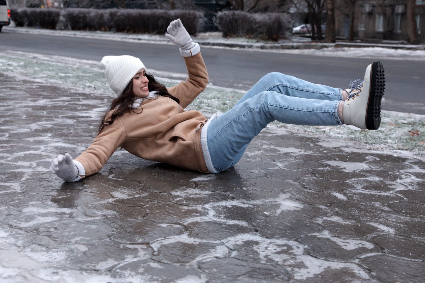 Women slips and falls on a slippery icey pavement