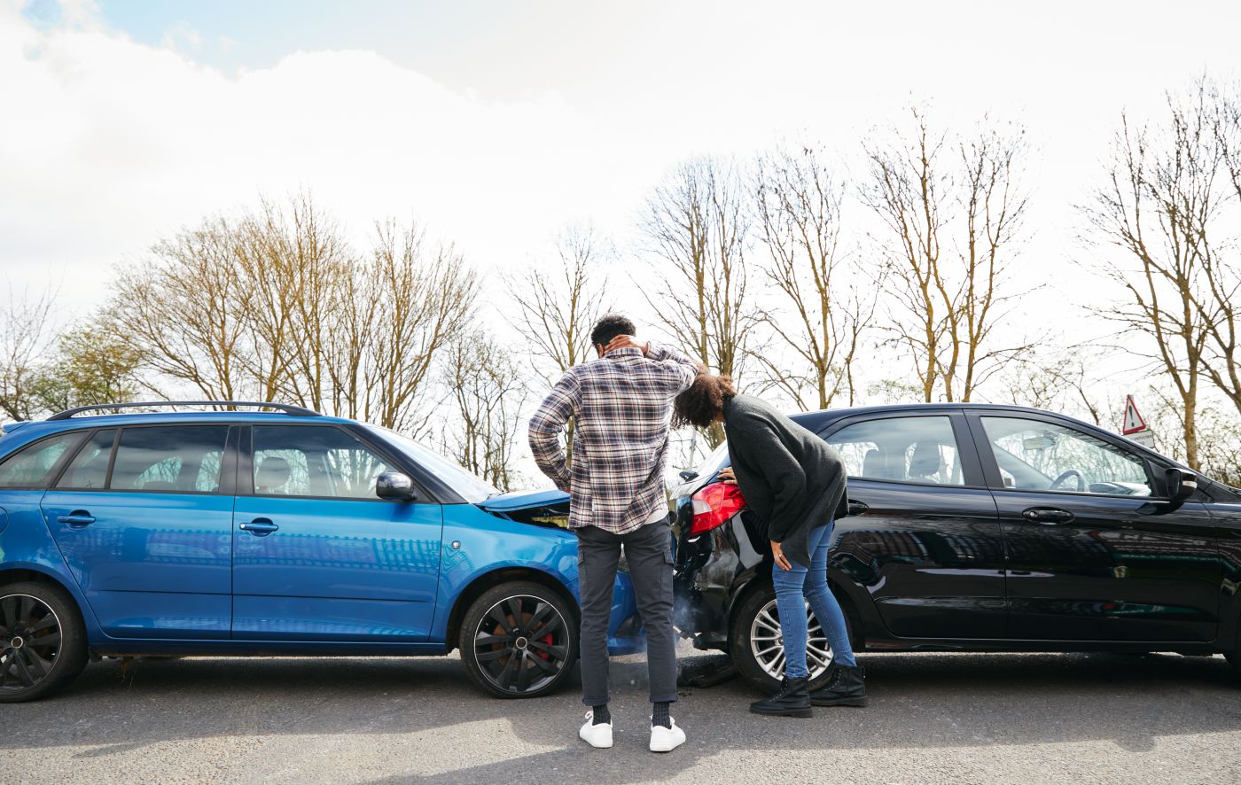 Drivers examining damage after car accident