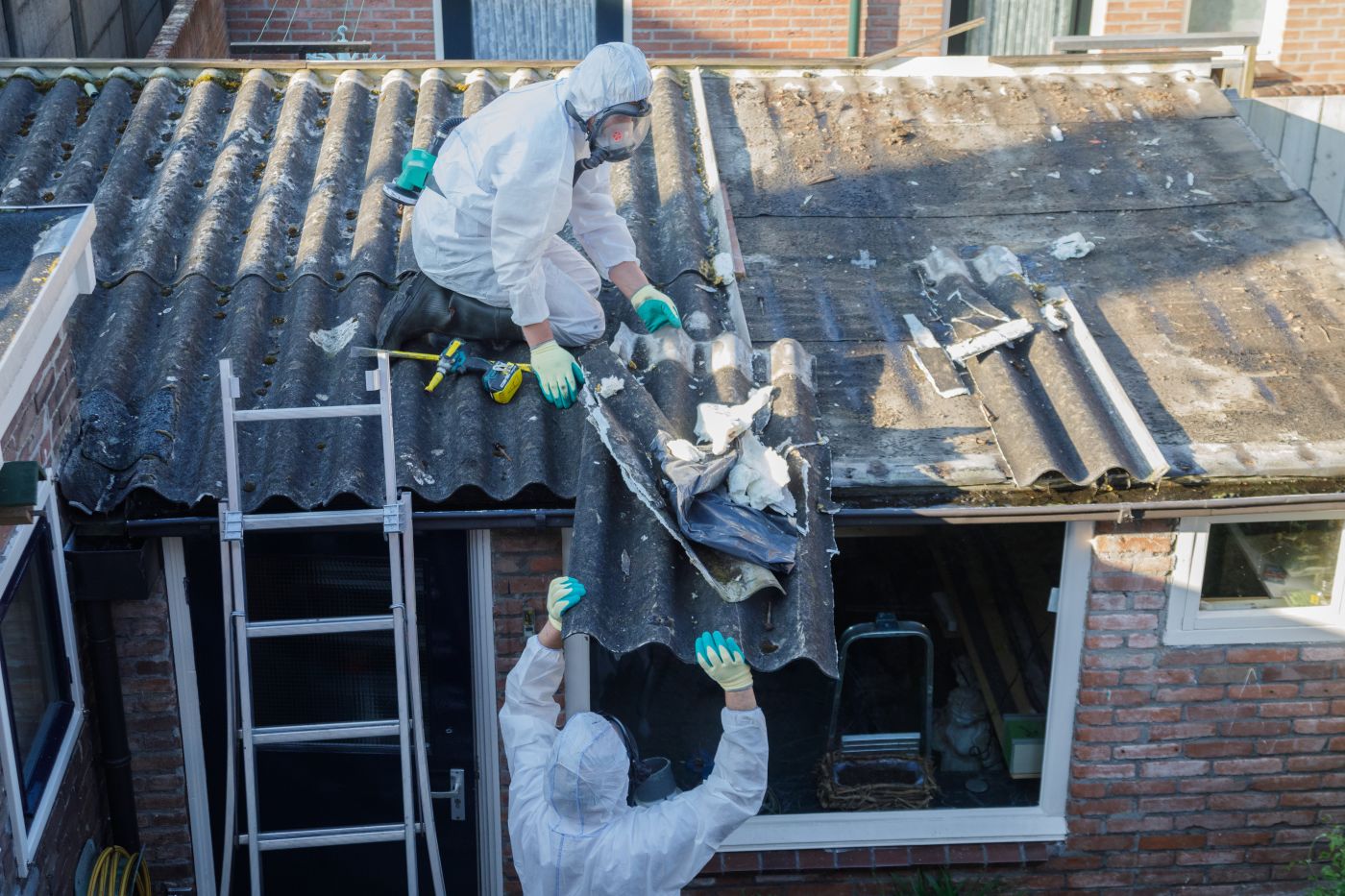 Man in protective suite removing asbestos