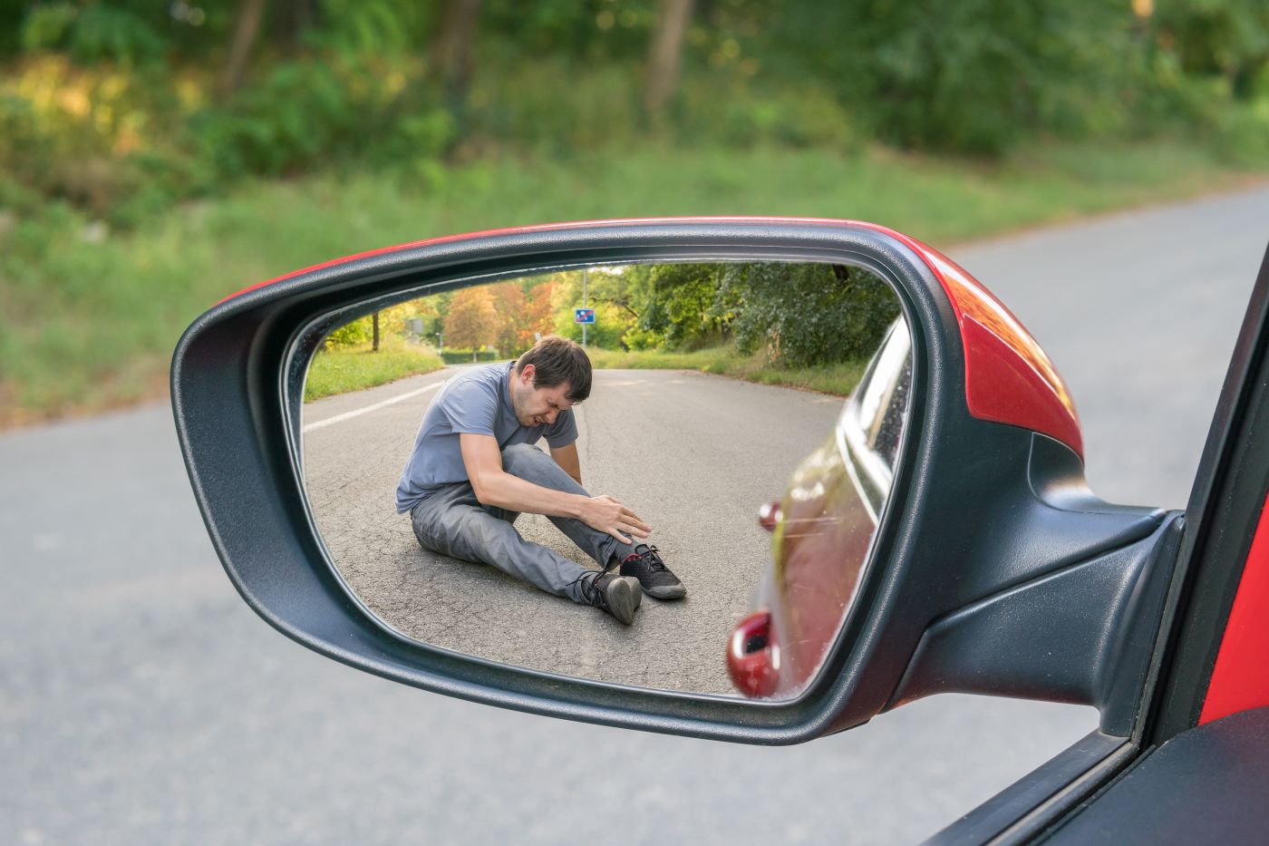 View of injured man on rear view of a car