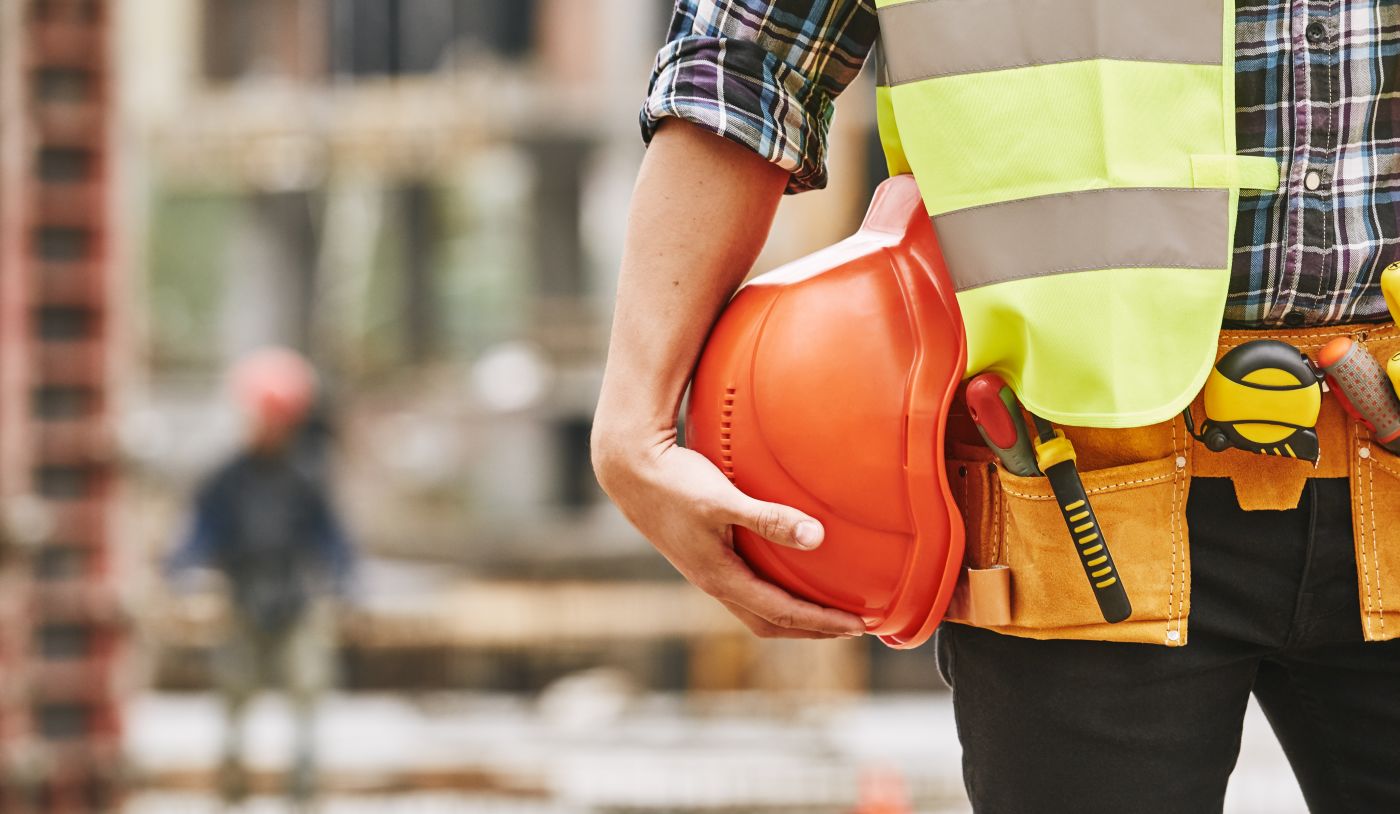 Construction worker with safety helmet and tools