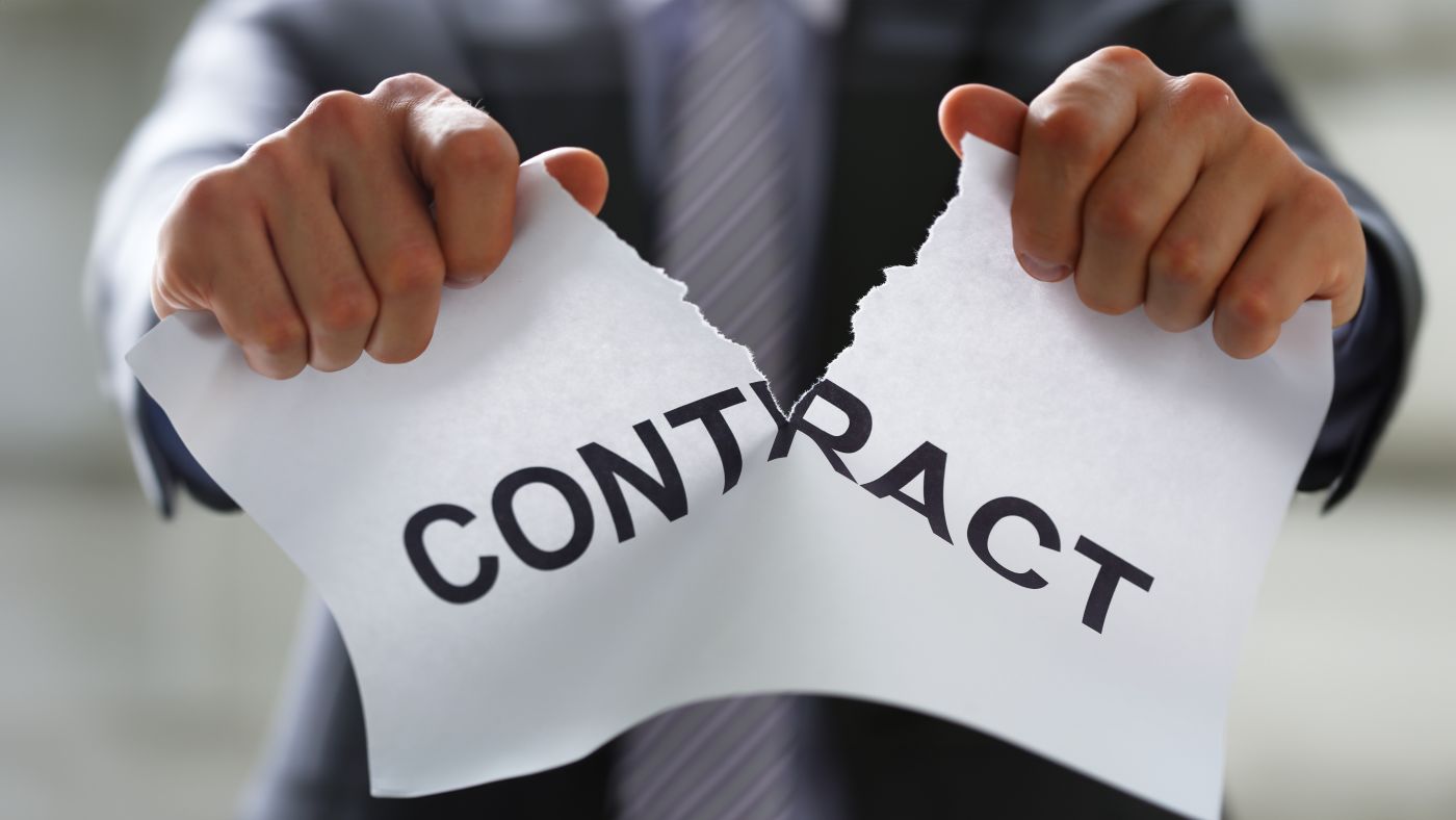 Businessman tearing contract paper