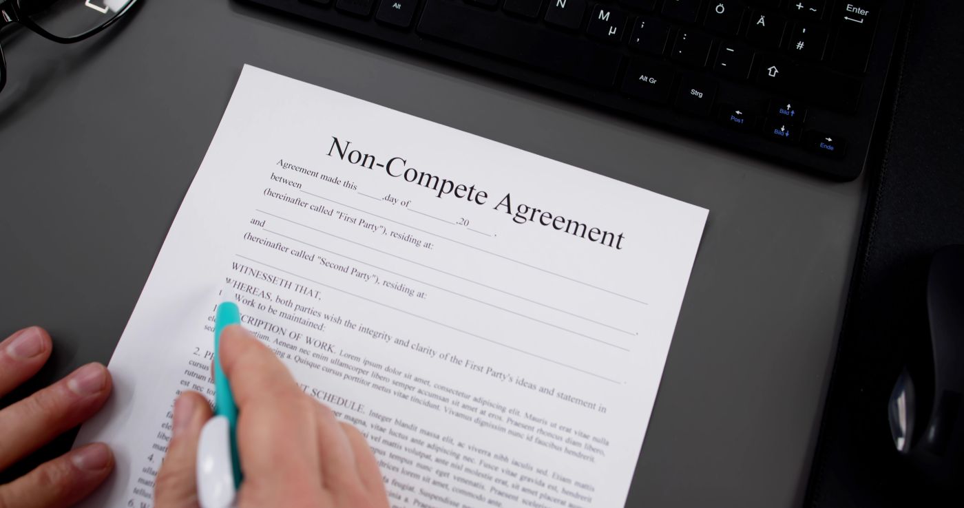 Man reading Non Compete Agreement before signing