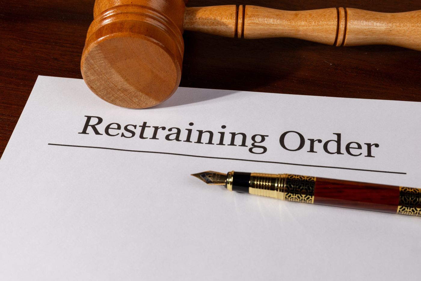Restraining Order file, gavel and pen in table