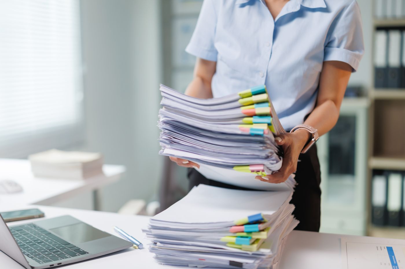 Businesswomen with stacks of documents in hand