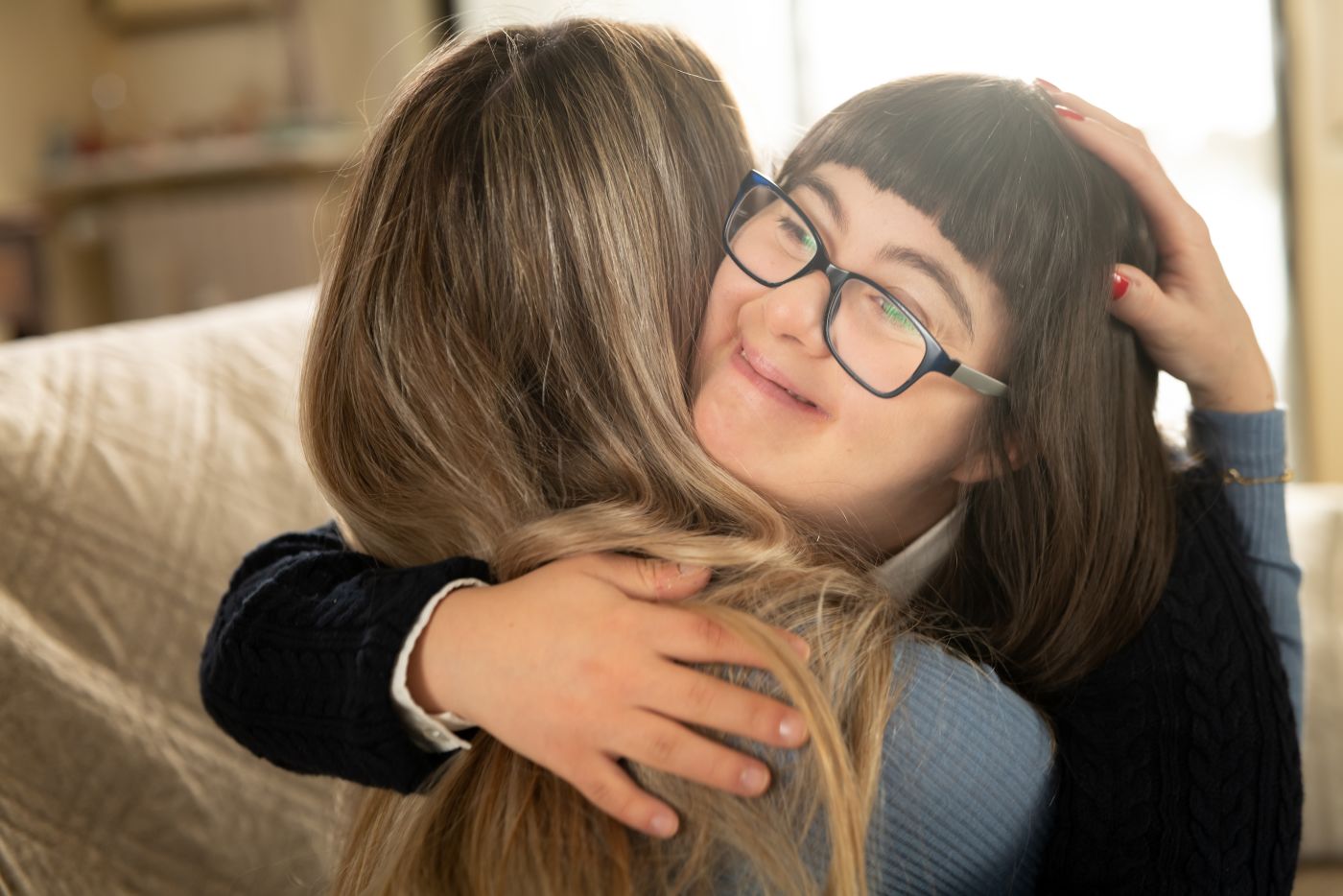 Little girl with down syndrome hugging her guardian