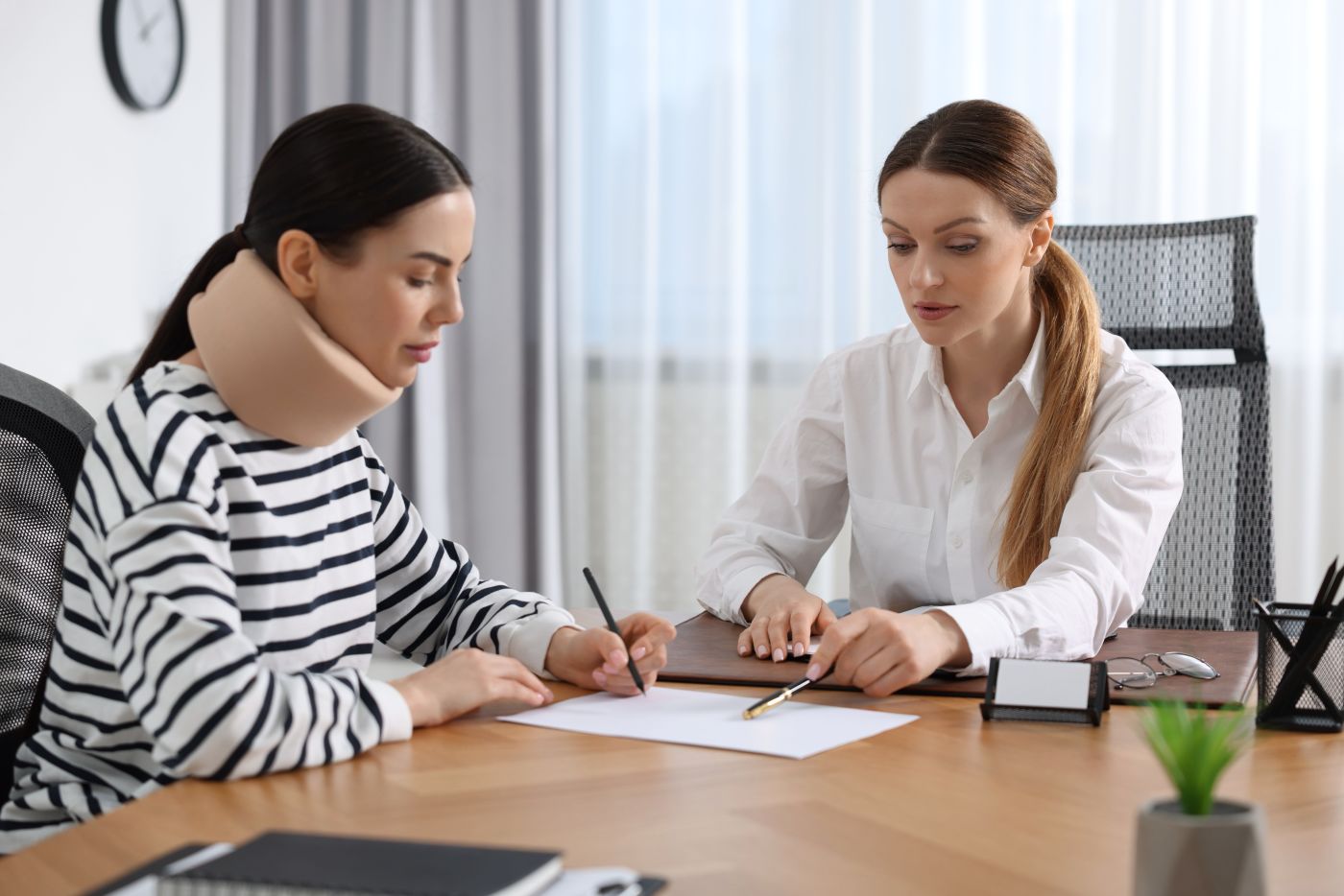 Women with whiplash injury consulting with attorney