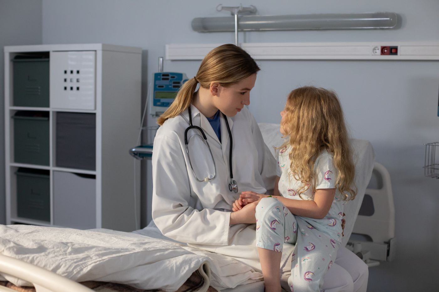 A caring doctor interacts warmly with a young girl