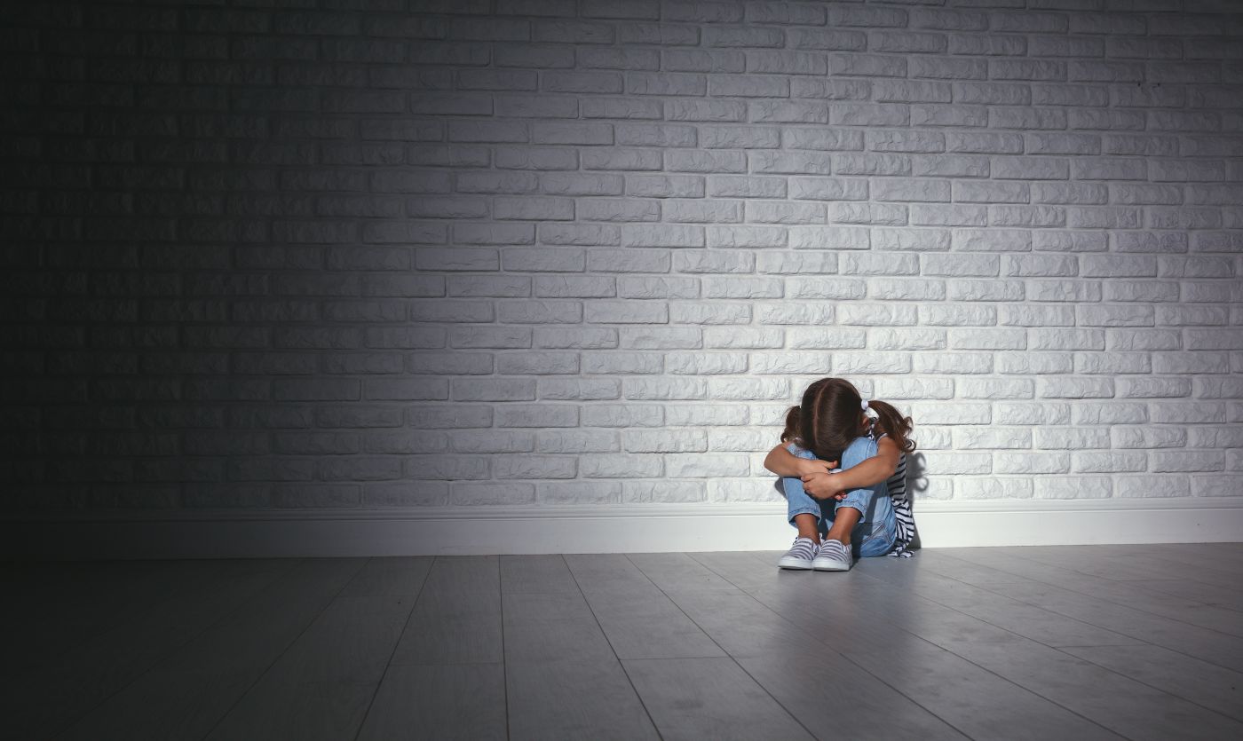 Upset child in dark corner