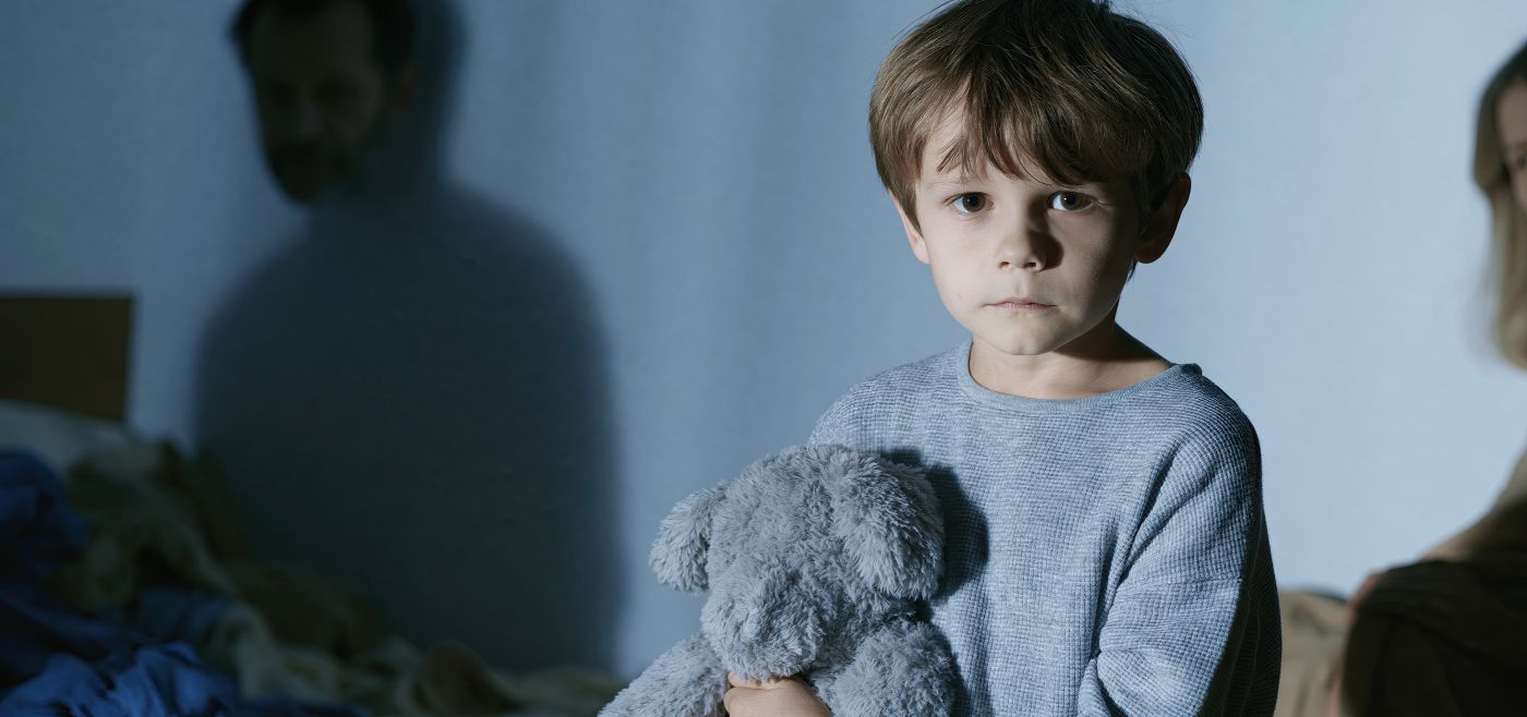 Child in a messy room holding a toy