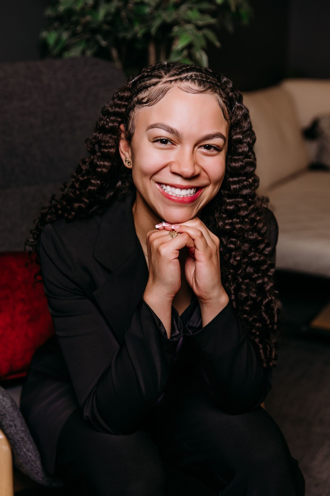 Legal Assistant Jazmyne Cook sitting in a chair smiling.