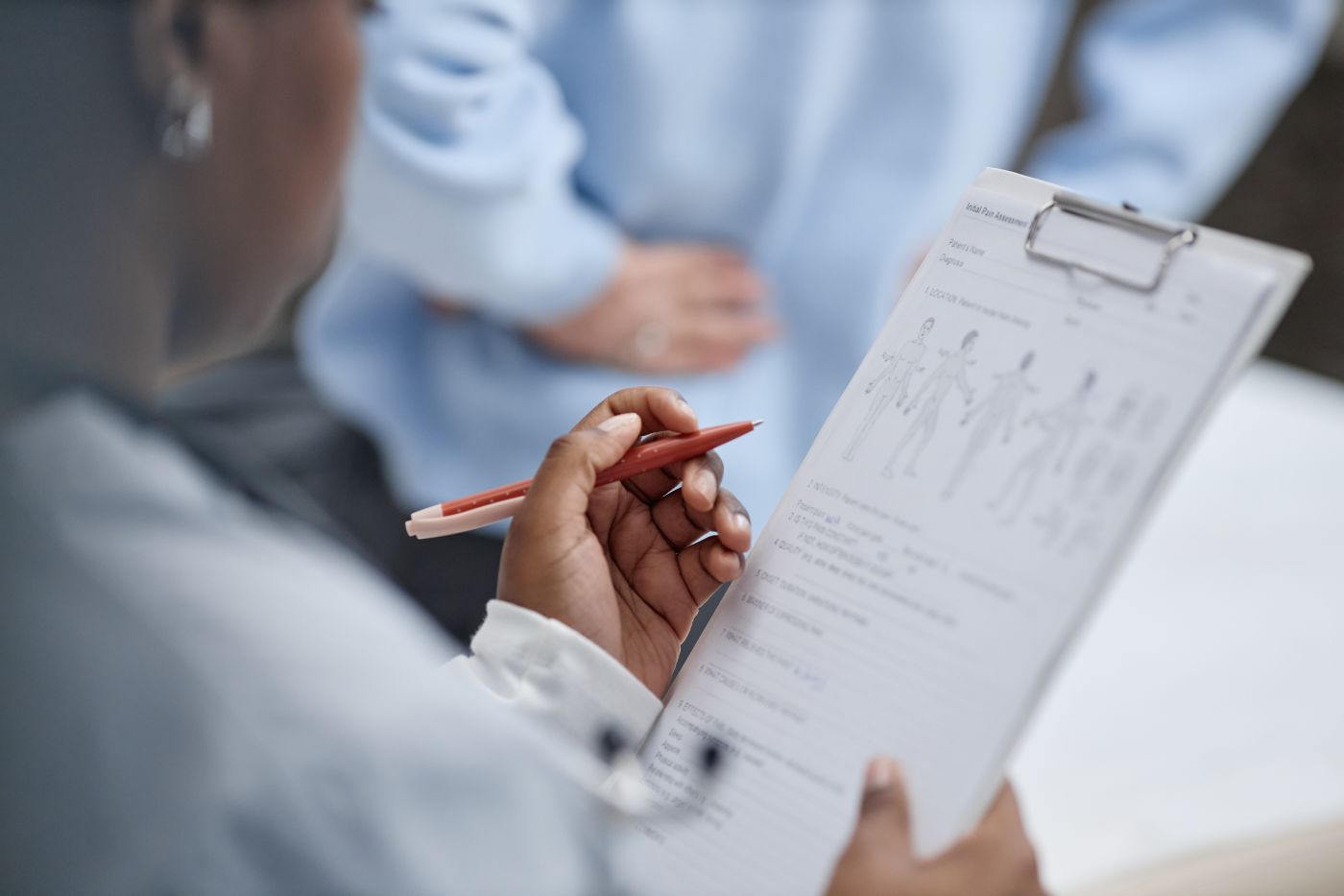 Medical person holding clipboard reviewing medical chart with anatomical diagrams