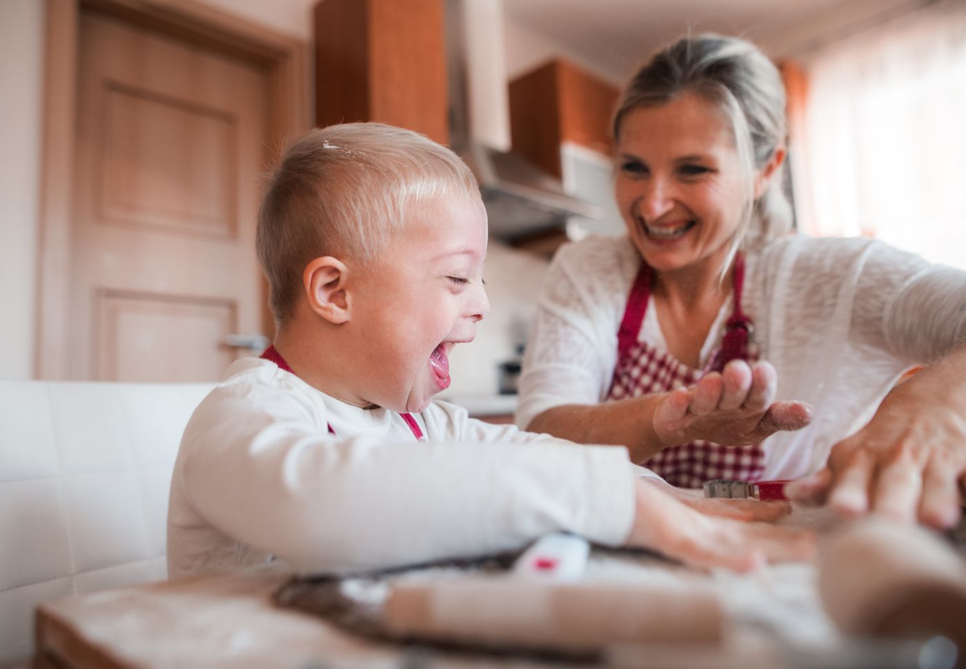 Special need child enjoying in kitchen with his mother