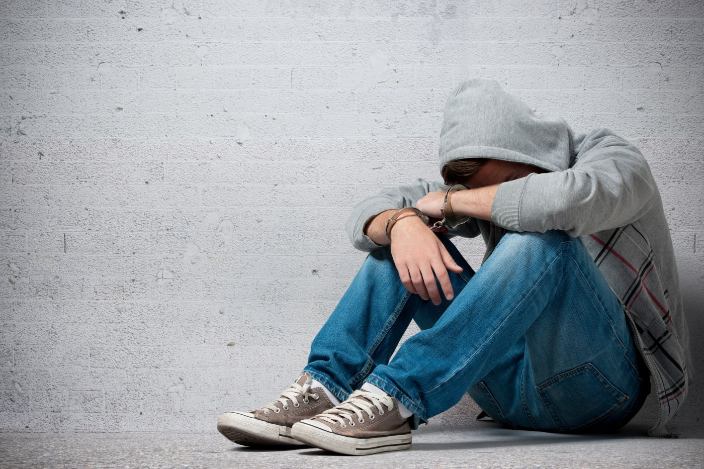 Arrested teenager with handcuffs on his hands