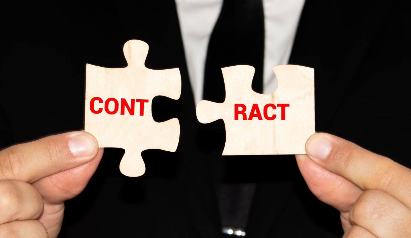 Man holding puzzle pieces with word Contract